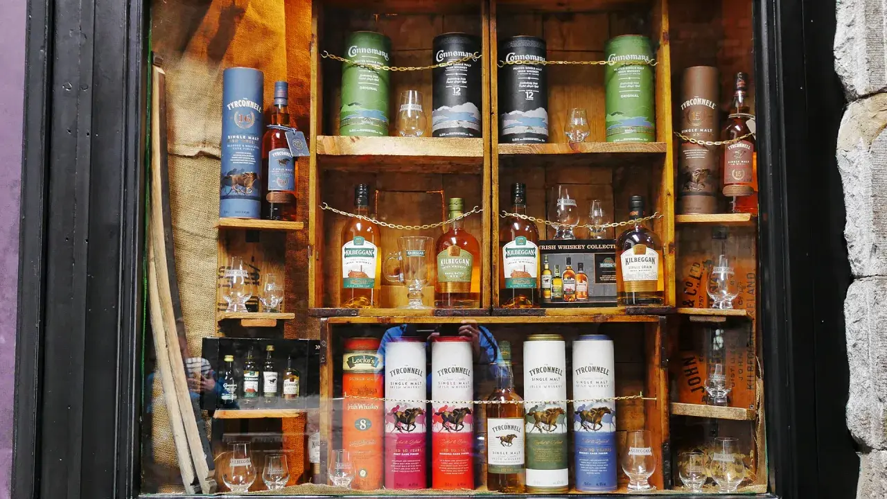 Regale voller Flaschen und Tuben mit irischem Whisky, bereit zum Whisky lagern. Verschiedene Marken wie Tyrconnell und Kilbeggan sind zu sehen.