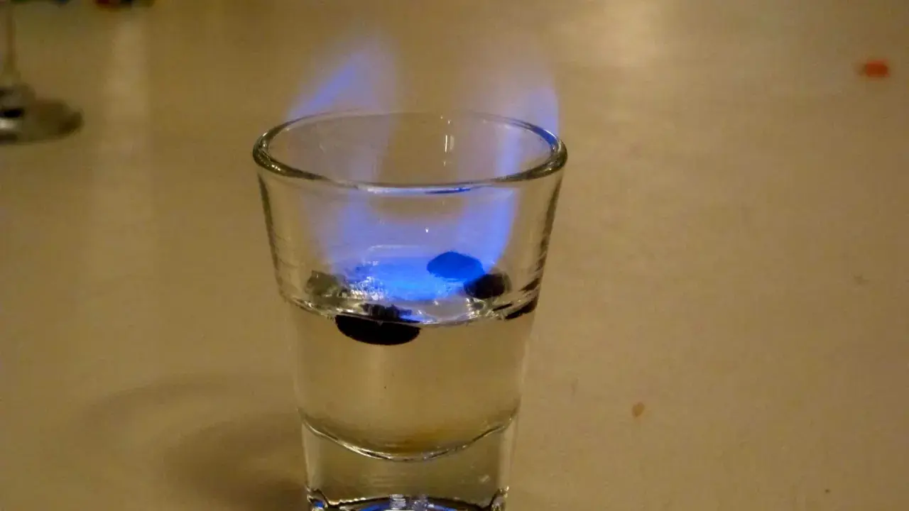 Ein Schnapsglas mit brennendem Sambuca und drei Kaffeebohnen. So schmeckt Sambuca: süß, anisartig und leicht scharf.
