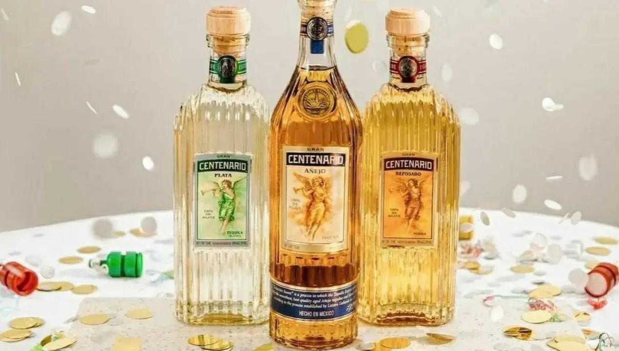 Drei Flaschen Gran Centenario Tequila: Plata, Añejo und Reposado. Feierliche Konfetti-Streusel umgeben die verschiedenen Tequila-Sorten.