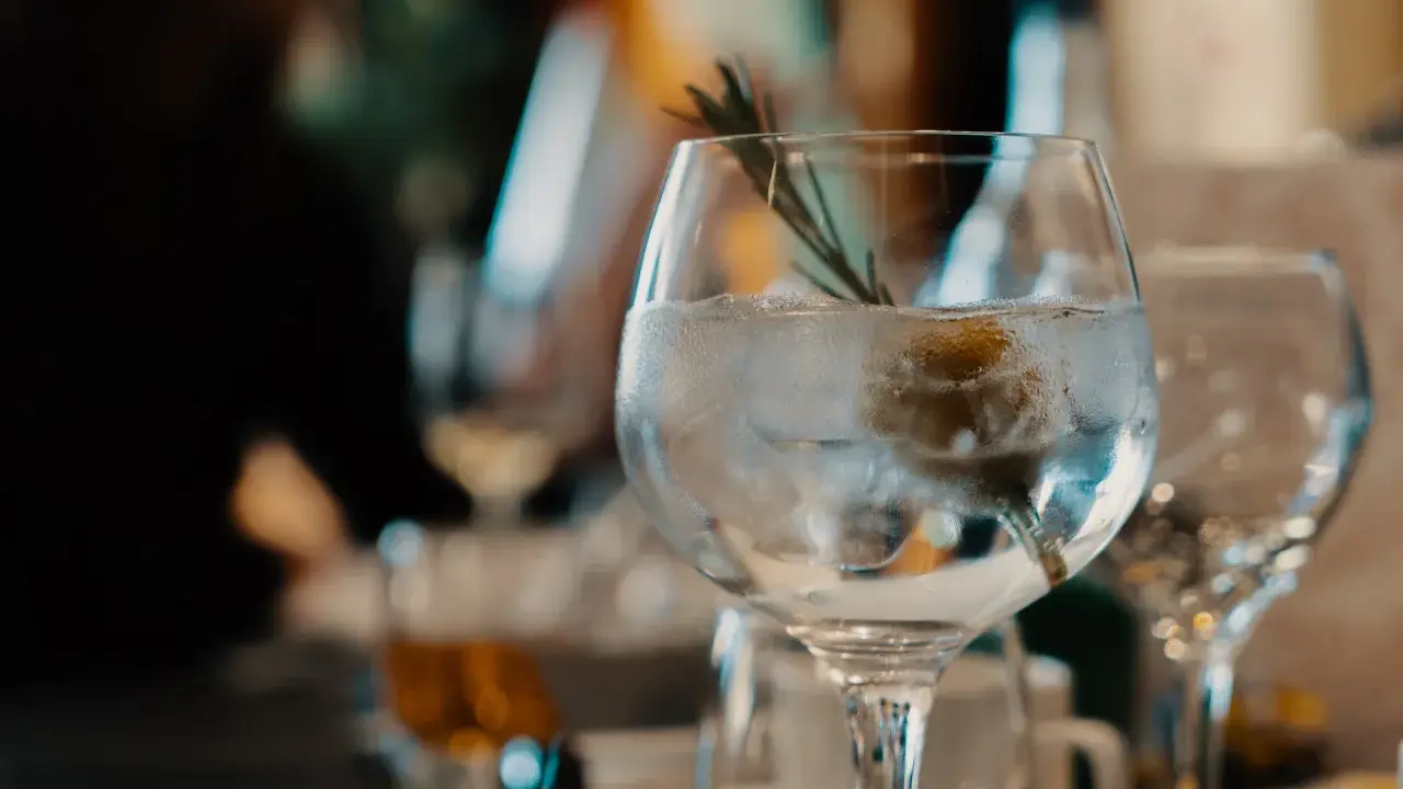 Ein erfrischender nordes Gin Tonic mit Eis, Zitrone und Rosmarin, bereit zum Genießen.