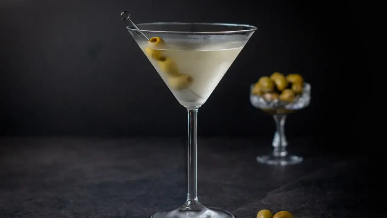 Ein klassischer Martini, garniert mit Oliven, zeigt, wie serviert man Martini für einen eleganten Genuss.