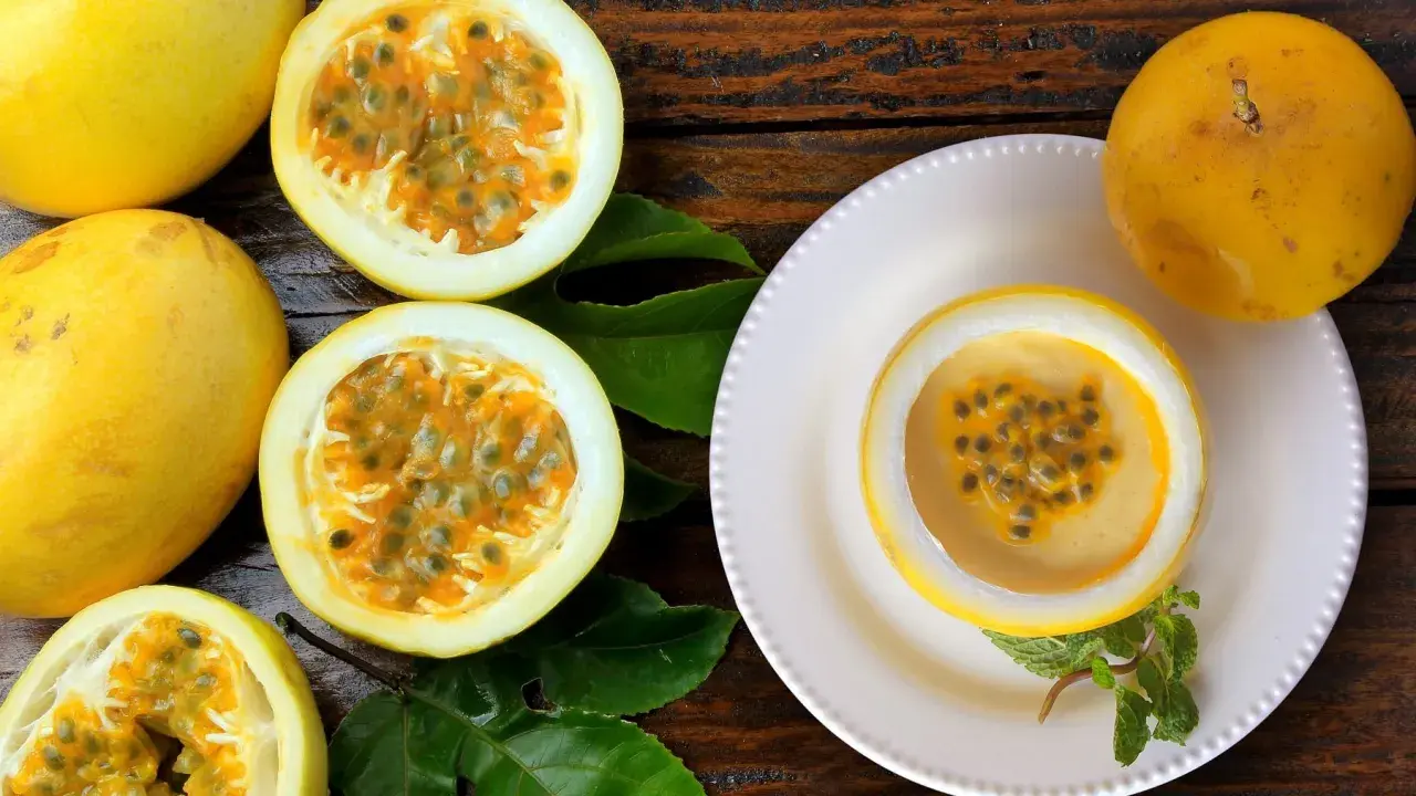 Passoa Spritz: Saftige Passionsfrüchte, eine davon als Schale für einen cremigen Drink, garniert mit Minze.
