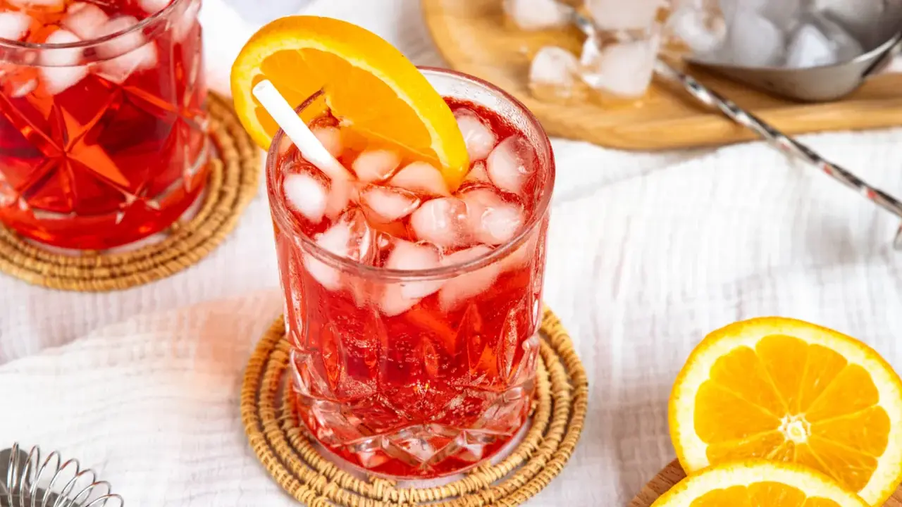 Erfrischender Campari Spritz mit Eis und Orangenscheibe, bereit für den Genuss.