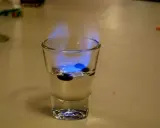Ein Schnapsglas mit brennendem Sambuca und drei Kaffeebohnen. So schmeckt Sambuca: süß, anisartig und leicht scharf.