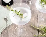 Erfrischender Gin Tonic mit Rosmarin und Eis. Ein Hauch von Kräutern für den perfekten Genuss.