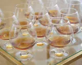 Viele Gläser mit bernsteinfarbenem Metaxa stehen bereit. Was ist Metaxa? Ein griechischer Weinbrand, der nach einer geheimen Rezeptur hergestellt wird.