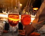 Zwei Aperol Spritz Gläser, bereit zum Genuss. Die leuchtende Farbe erinnert an die Aperol Herkunft in Italien.