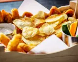 Knusprige Kartoffelchips, frittierte Hähnchenteile und Gemüsesticks – ein perfekter Snack, der gut zu Gin passt.