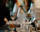 Ein erfrischender nordes Gin Tonic mit Eis, Zitrone und Rosmarin, bereit zum Genießen.