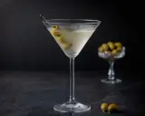 Ein klassischer Martini, garniert mit Oliven, zeigt, wie serviert man Martini für einen eleganten Genuss.