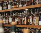 Regale voller Flaschen mit goldbraunem Whisky oder Whiskey. Eine Auswahl für Kenner.