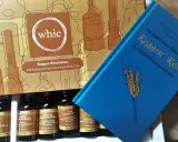 Whisky-Tasting-Set "Roggen-Revolution" mit vier Flaschen Rye Whiskey und einem Buch über die Karriere von Roggen als Getreide.