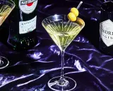 Ein Martini mit Oliven, daneben Martini Extra Dry und Hendrick's Gin. Verschiedene Martini Sorten für den perfekten Drink.