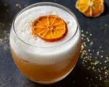 Ein cremiger Amaretto Cocktail mit einem getrockneten Orangenscheibchen und goldenem Glitzer.