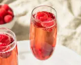 Zwei Gläser Kir Royal mit frischen Himbeeren. Ein einfaches Kir Royal Rezept für besondere Momente.