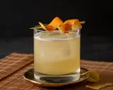 Ein erfrischender Cocktail mit Eis, garniert mit Orangenschale. Für die Süße wurde Zuckersirup verwendet, was ist Zuckersirup? Eine einfache Mischung aus Zucker und Wasser.