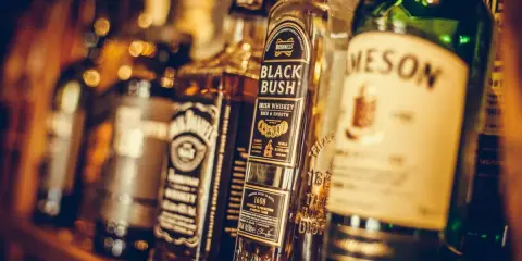 Regal mit verschiedenen irischer whiskey sorten, darunter Bushmills Black Bush und Jameson.