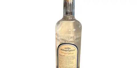 Eine Flasche Ouzo mit korken. Der Etikett beschreibt den Ouzo Geschmack und die Geschichte des Getränks.