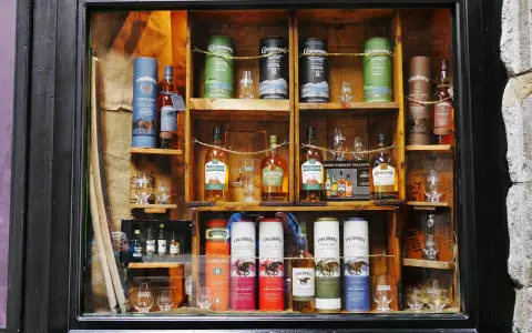 Regale voller Flaschen und Tuben mit irischem Whisky, bereit zum Whisky lagern. Verschiedene Marken wie Tyrconnell und Kilbeggan sind zu sehen.