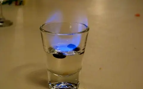 Ein Schnapsglas mit brennendem Sambuca und drei Kaffeebohnen. So schmeckt Sambuca: süß, anisartig und leicht scharf.