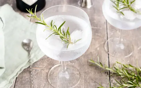 Erfrischender Gin Tonic mit Rosmarin und Eis. Ein Hauch von Kräutern für den perfekten Genuss.