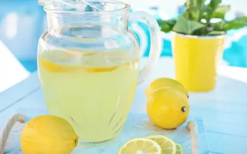 Erfrischende Limonade im Krug, garniert mit Zitronenscheiben. Perfekter zitronensaft ersatz für heiße Tage.