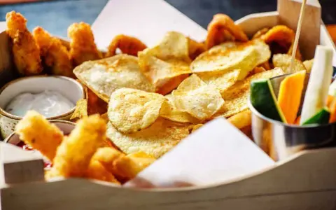 Knusprige Kartoffelchips, frittierte Hähnchenteile und Gemüsesticks – ein perfekter Snack, der gut zu Gin passt.