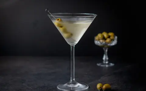Ein klassischer Martini, garniert mit Oliven, zeigt, wie serviert man Martini für einen eleganten Genuss.