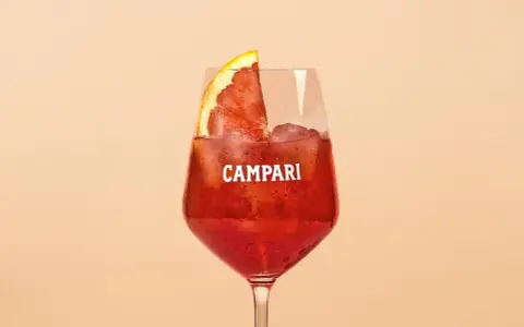 Ein erfrischender Campari Cocktail mit Eis und einer Orangenscheibe, perfekt für einen warmen Abend.