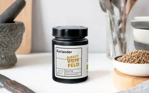Ein Glas Koriandersamen steht bereit, um Gerichten Aroma zu verleihen. Perfekt zum Koriander samen essen!