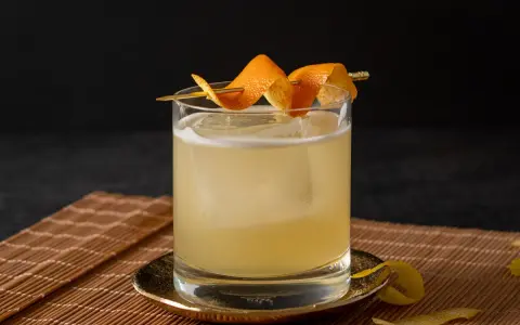 Erfrischender Cocktail mit Eis, garniert mit Orangenzesten. Eine köstliche zuckersirup alternative für Genießer.
