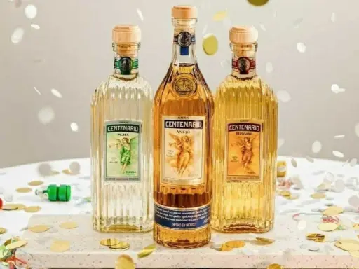 Drei Flaschen Gran Centenario Tequila: Plata, Añejo und Reposado. Feierliche Konfetti-Streusel umgeben die verschiedenen Tequila-Sorten.