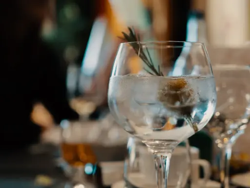 Ein erfrischender nordes Gin Tonic mit Eis, Zitrone und Rosmarin, bereit zum Genießen.