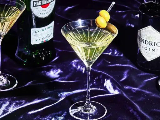 Ein Martini mit Oliven, daneben Martini Extra Dry und Hendrick's Gin. Verschiedene Martini Sorten für den perfekten Drink.
