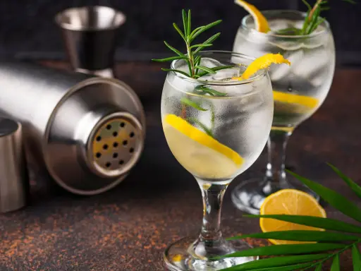 Zwei erfrischende Gin Tonic mit Zitrone und Rosmarin, bereit für den perfekten Genuss. Der passende prozentuale Alkoholgehalt macht sie zum idealen Sommerdrink.