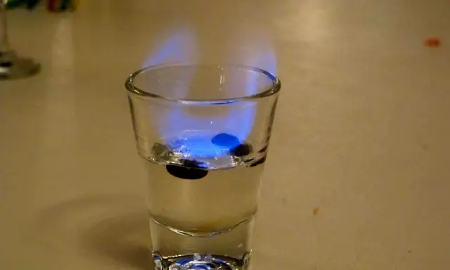 Ein Schnapsglas mit brennendem Sambuca und drei Kaffeebohnen. So schmeckt Sambuca: süß, anisartig und leicht scharf.