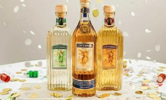 Drei Flaschen Gran Centenario Tequila: Plata, Añejo und Reposado. Feierliche Konfetti-Streusel umgeben die verschiedenen Tequila-Sorten.