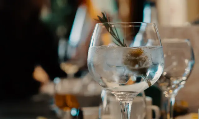 Ein erfrischender nordes Gin Tonic mit Eis, Zitrone und Rosmarin, bereit zum Genießen.