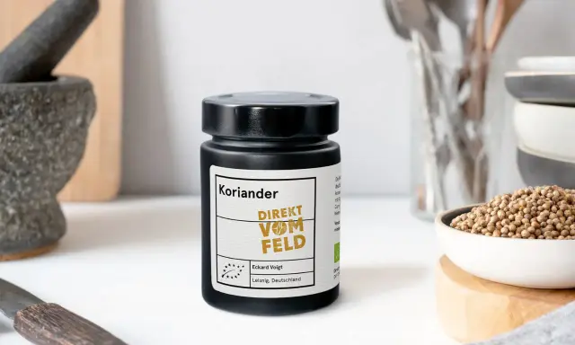 Ein Glas Koriandersamen steht bereit, um Gerichten Aroma zu verleihen. Perfekt zum Koriander samen essen!