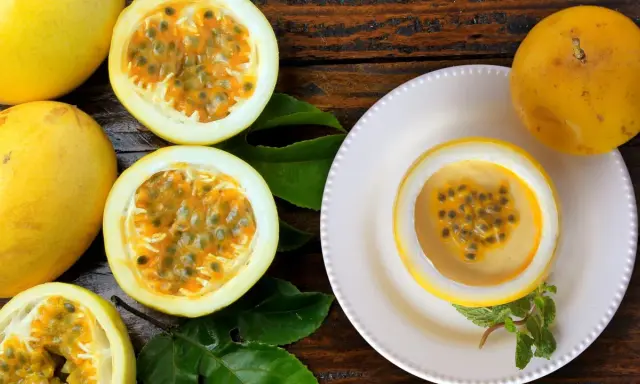 Passoa Spritz: Saftige Passionsfrüchte, eine davon als Schale für einen cremigen Drink, garniert mit Minze.