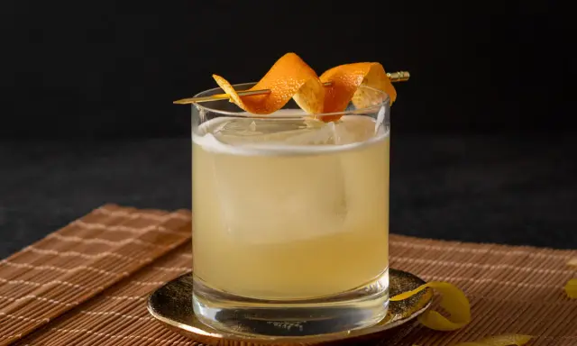 Ein erfrischender Cocktail mit Eis, garniert mit Orangenschale. Für die Süße wurde Zuckersirup verwendet, was ist Zuckersirup? Eine einfache Mischung aus Zucker und Wasser.
