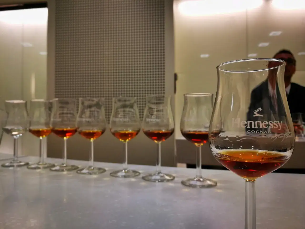 Verkostung von Hennessy Cognac: So trinkt man ihn richtig. Mehrere Gläser mit bernsteinfarbener Flüssigkeit stehen nebeneinander.