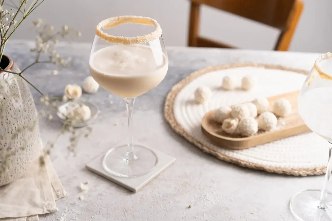 Cremiger Drink mit Kokosrand, dazu Mandelkugeln. Perfekt, wenn Sie Mandelsirup selber machen möchten.