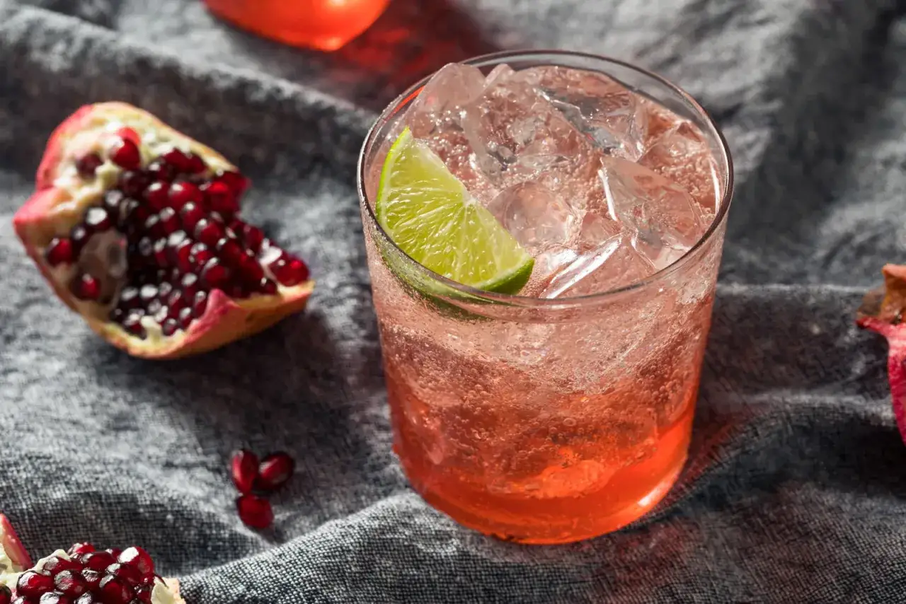 Erfrischender Drink mit Granatapfelkernen und Limette. Was ist Grenadine? Ein s&uuml;&szlig;er Sirup, der oft f&uuml;r Cocktails verwendet wird.