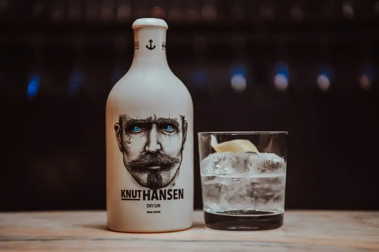 Knut Hansen Gin mit Tonic Water und Eiswürfeln, garniert mit einer Zitronenspalte. Ein perfekter Drink für den Sommer.