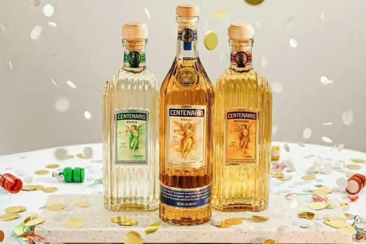 Drei Flaschen Gran Centenario Tequila: Plata, Añejo und Reposado. Verschiedene Tequila Sorten für jede Gelegenheit, umgeben von Konfetti.