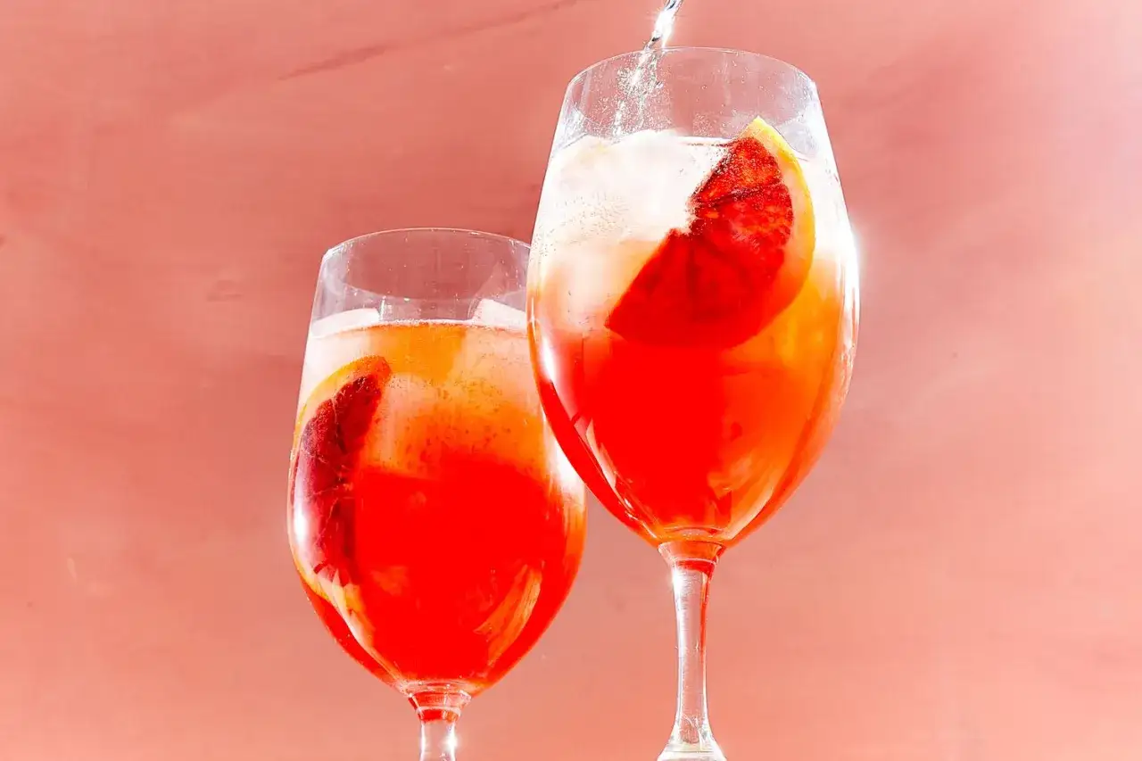 Zwei leuchtend rote Campari Cocktails mit Orangenscheiben und Eiswürfeln, bereit zum Genießen.