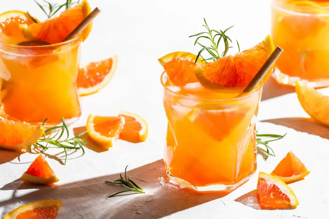 Erfrischender Drink mit Orangenscheiben und Rosmarin. Vielleicht ein Cocktail mit Triple Sec?